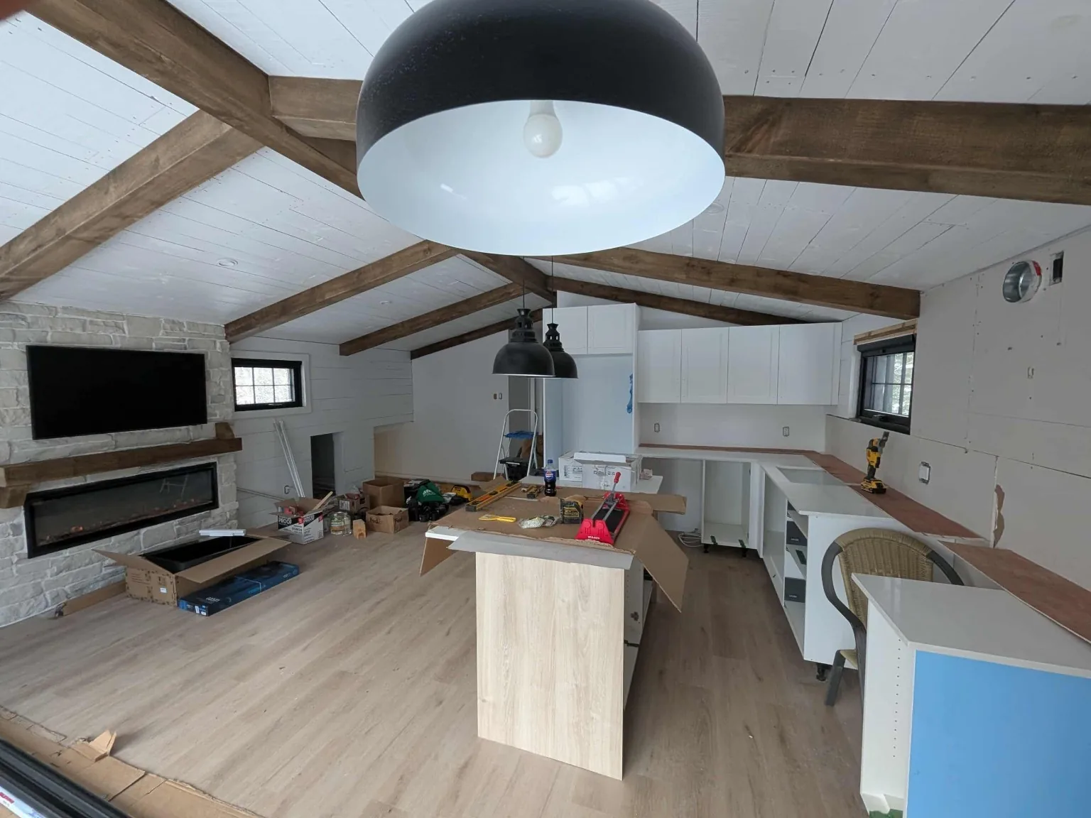Loft aménagé avec plafond cathédrale, poutres apparentes et cuisine